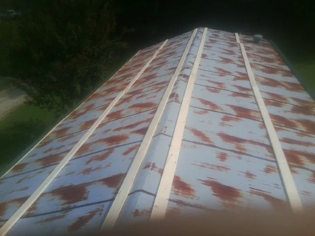 Rusted metal roof panels with new wood purlins before replacement — Storm Damage Roof Repair in Blandinsville by Roofing Brothers