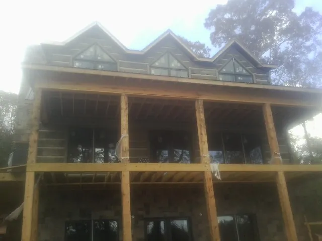 Dormers and porch framing on a large log home under construction in Blandinsville