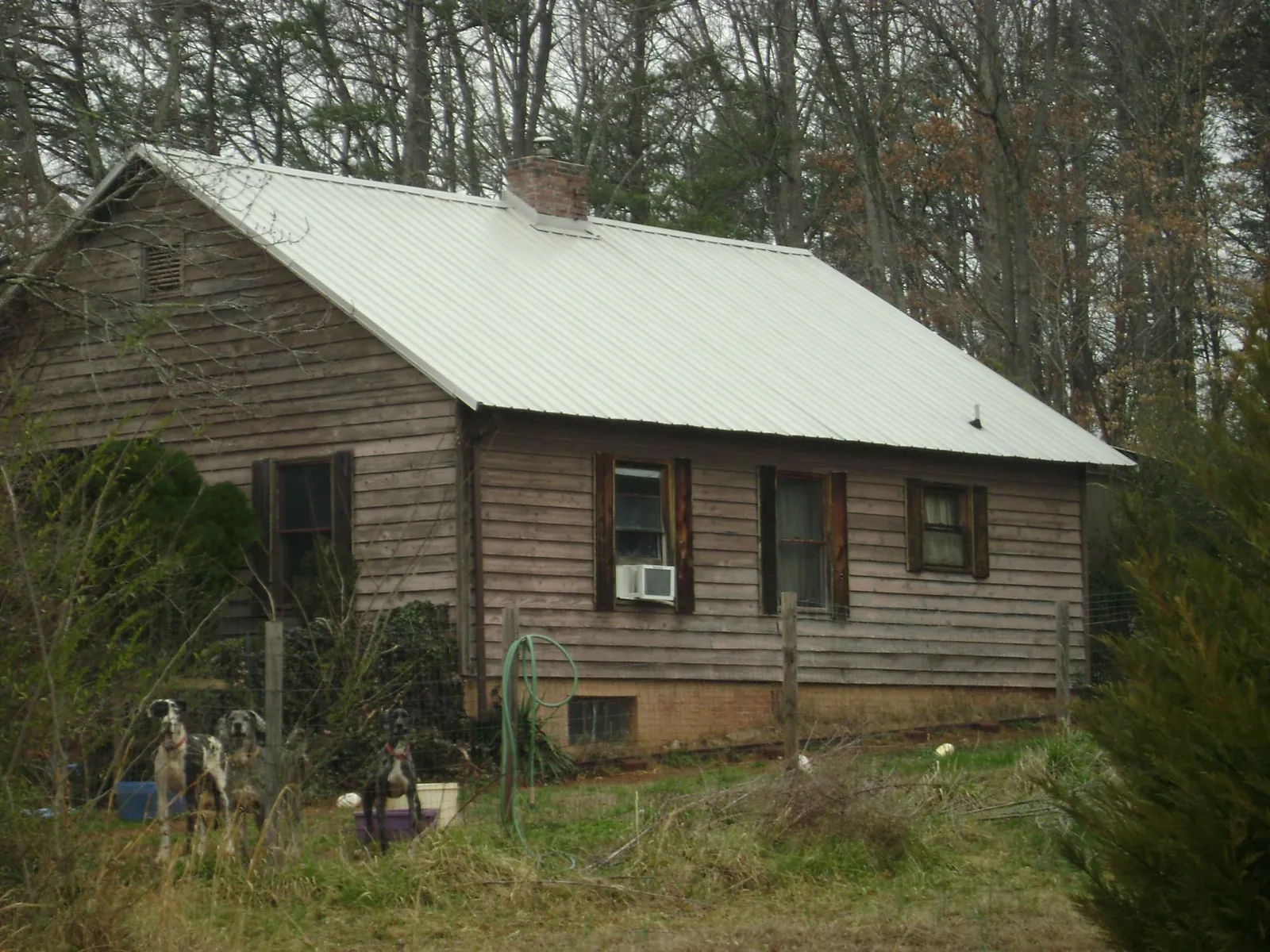 White metal roof on an old wood sided farmhouse, from a Metal Roof Installation job in Blandinsville